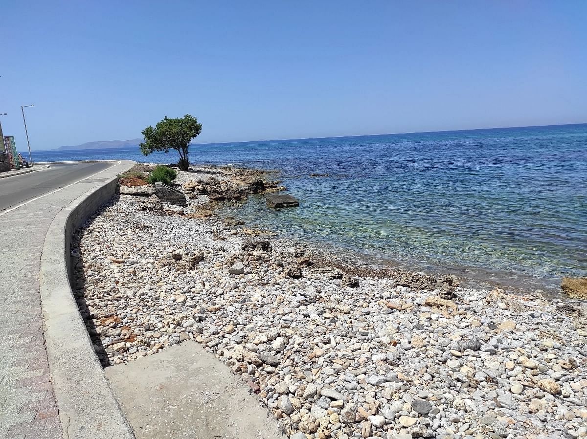 Ο γραφικός παραλιακός δρόμος των Κάτω Γουβών προσφέρει μια γραφική θέα σε ένα ζωντανό θαλάσσιο τοπίο, διακοσμημένο με το πλούσιο πράσινο των αλμυρίκια που κοσμούν την ακτογραμμή.